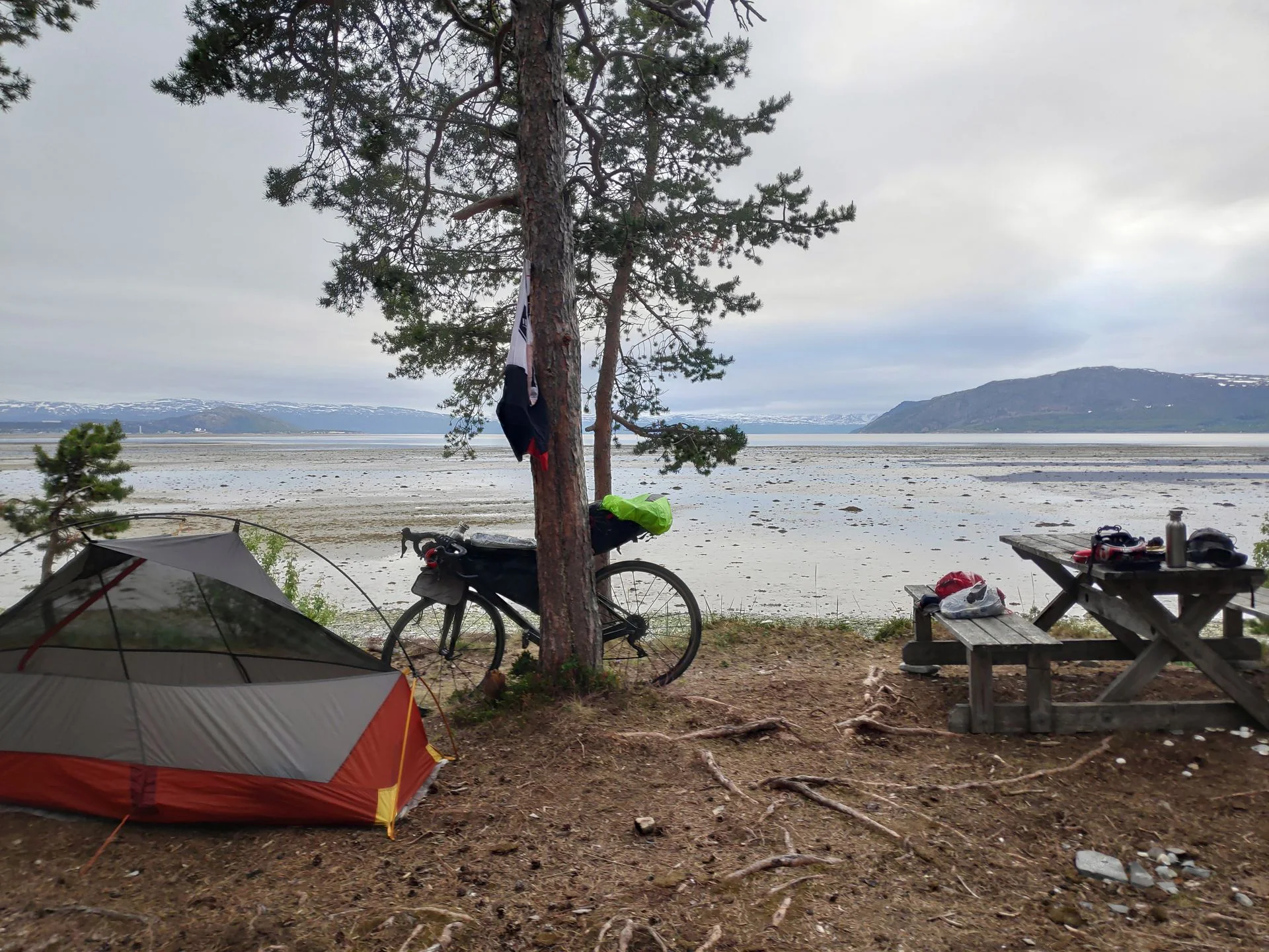 Une tente et un vélo installés près d’un lac